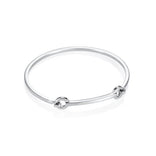 Efva Attlingin kiiltävä hopeinen cuff-rannerengas, jossa on siro pyöreä muoto ja kaksi pyöreää koristeosaa.
