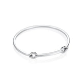 Efva Attlingin kiiltävä hopeinen cuff-rannerengas, jossa on siro pyöreä muoto ja kaksi pyöreää koristeosaa.