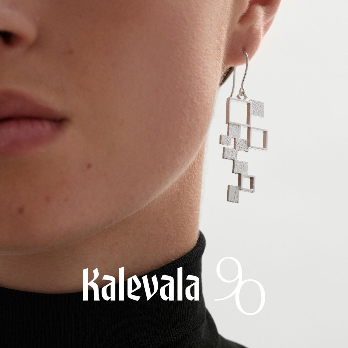 Kalevalan hopeinen Himmeli-korvakoru korvassa, ilmava geometrinen muoto ja näyttävät neliömäiset osat.