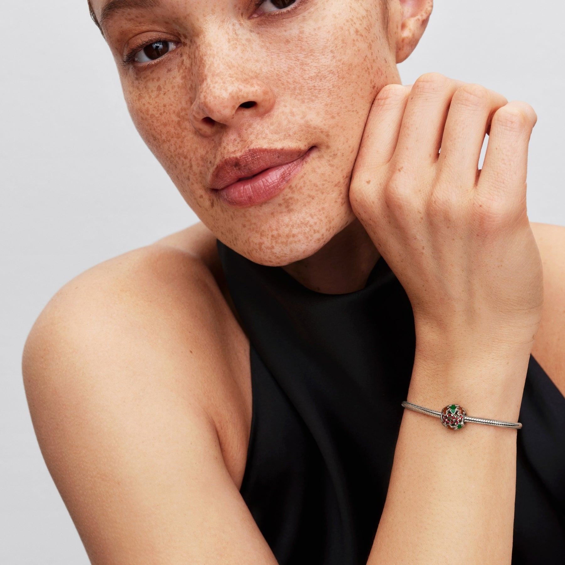 Pandora Moments platinapinnoitettu hela rannekorussa, jossa on värikäs jouluaiheinen emalikuviointi woman ranteessa
