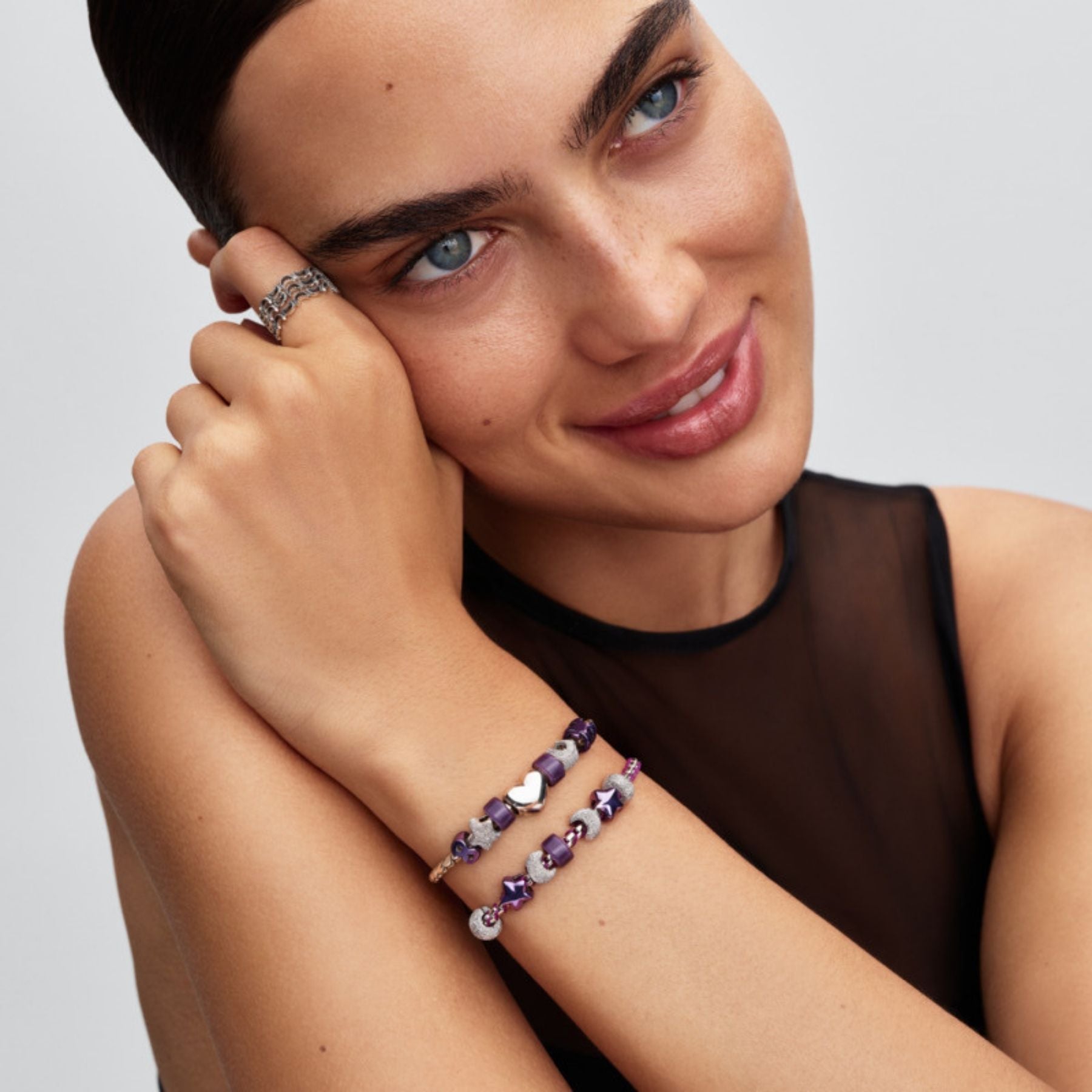 Pandora Purple Puzzle Piece Mini -hela violetilla emalilla hopeisessa rannekorussa muiden violettien ja valkoisten helien rinnalla