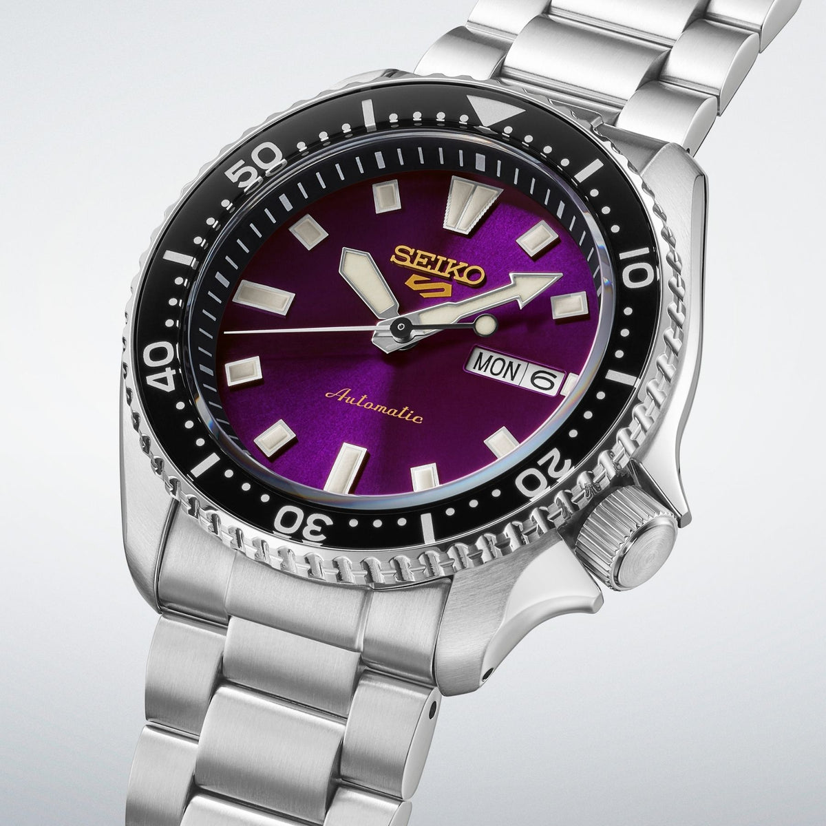 Seiko 5 Sports automaattinen rannekello violetilla taululla, teräsrannekkeella ja mustalla pyörivällä kehyksellä