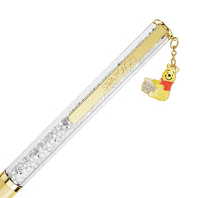 Swarovski kristallikynä kultaisella nimilaatalla ja Nalle Puh -riipuksella valkoisella taustalla