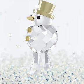 Swarovski kristallinen lumiukko kullanvärisellä silinterihatulla, nenällä ja napeilla kimaltavien koristekiteiden keskellä