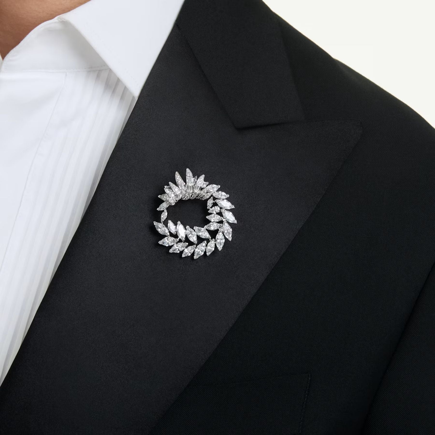 Swarovski rintakoru mustalla jakulla, vaalean metallin säihkyvä lehtikuvioinen kehä kirkkailla zirkoneilla